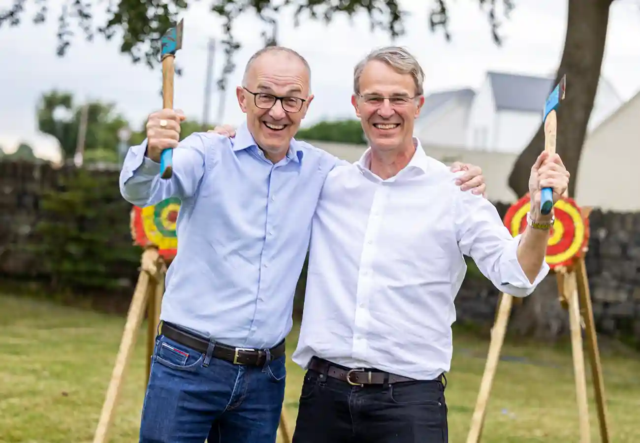 Men smiling after playing axe throwing at SAP 25 Anniversary Galway